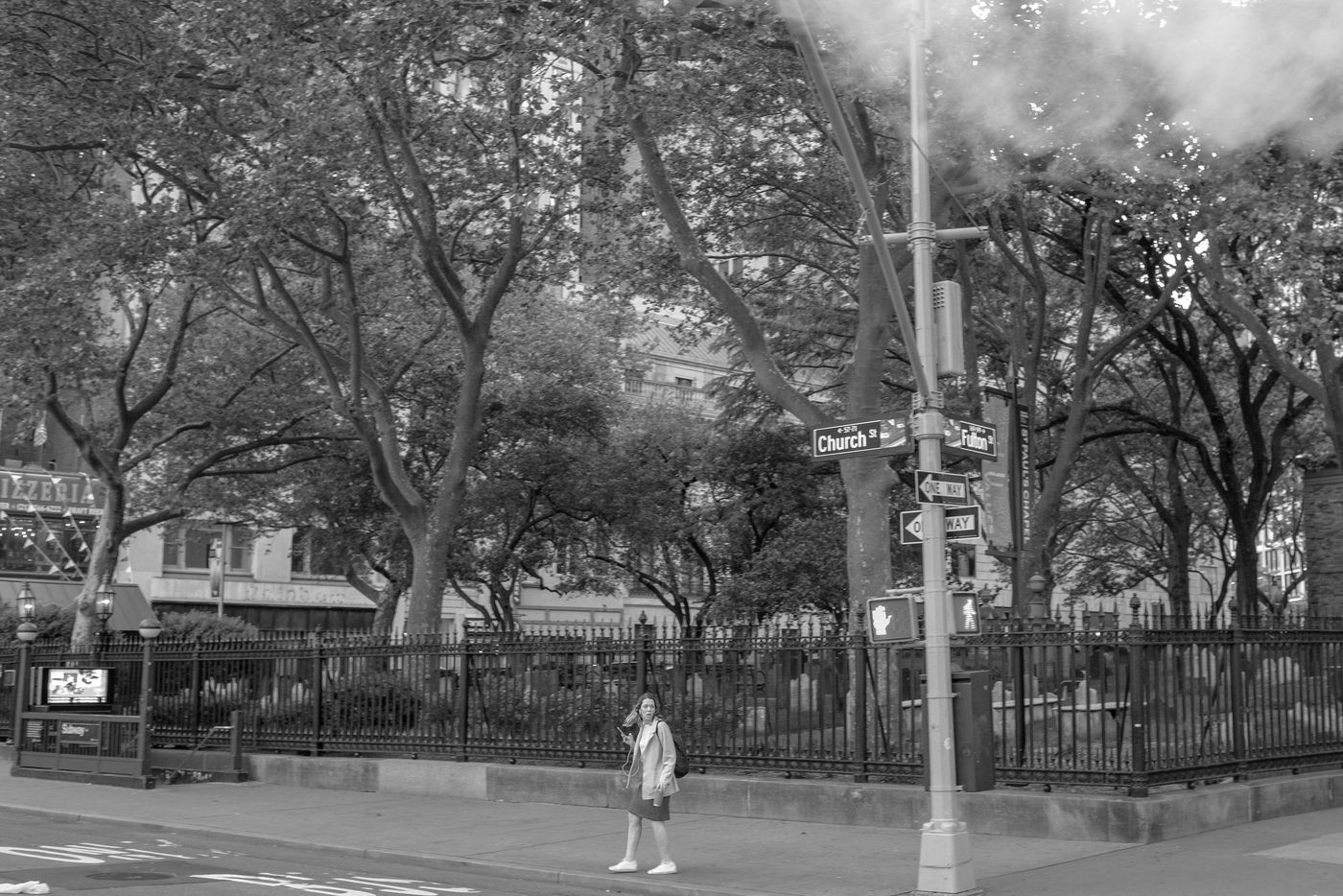 Woman crossing at the intersection of Church Street and Fulton Street, New York