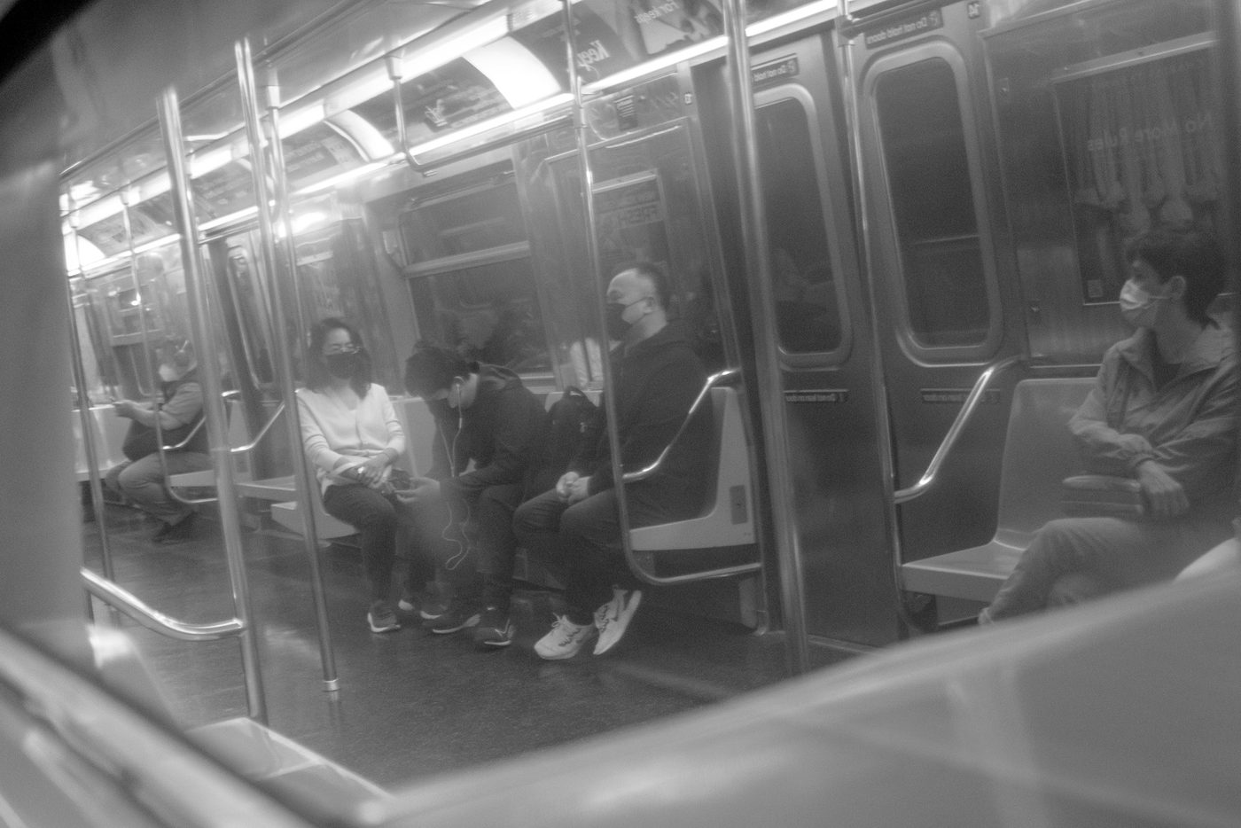 Masked passengers sitting in a subway car, New York