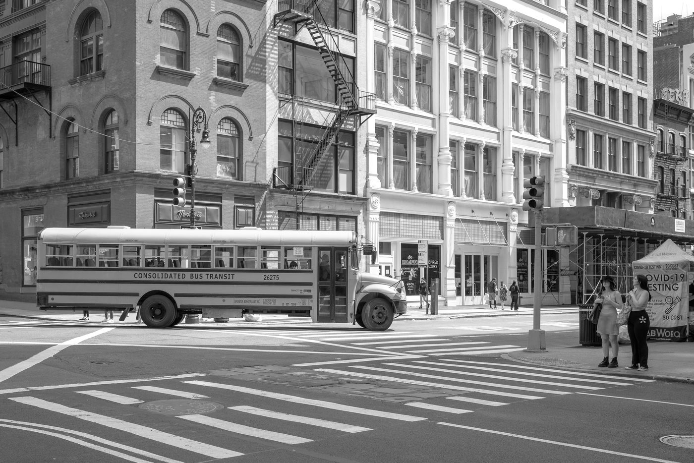 School bus turning past SoHo's cast-iron facades, New York