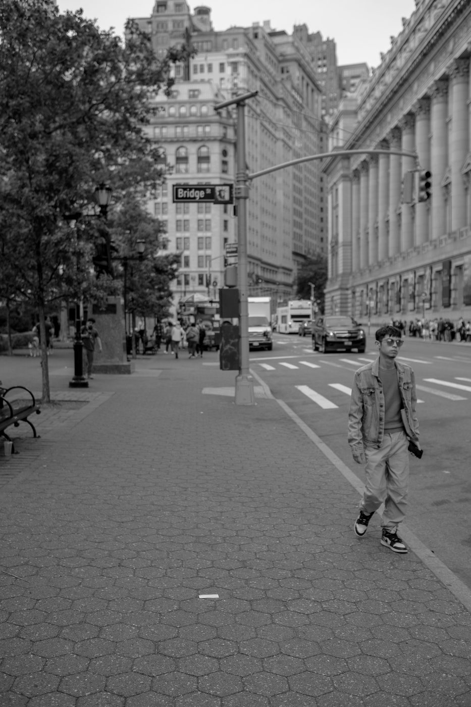 Young man in a denim jacket walking alone down an empty street, New York