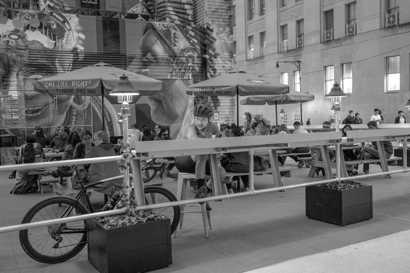 Helmeted cyclist seated in a lively urban garden, New York