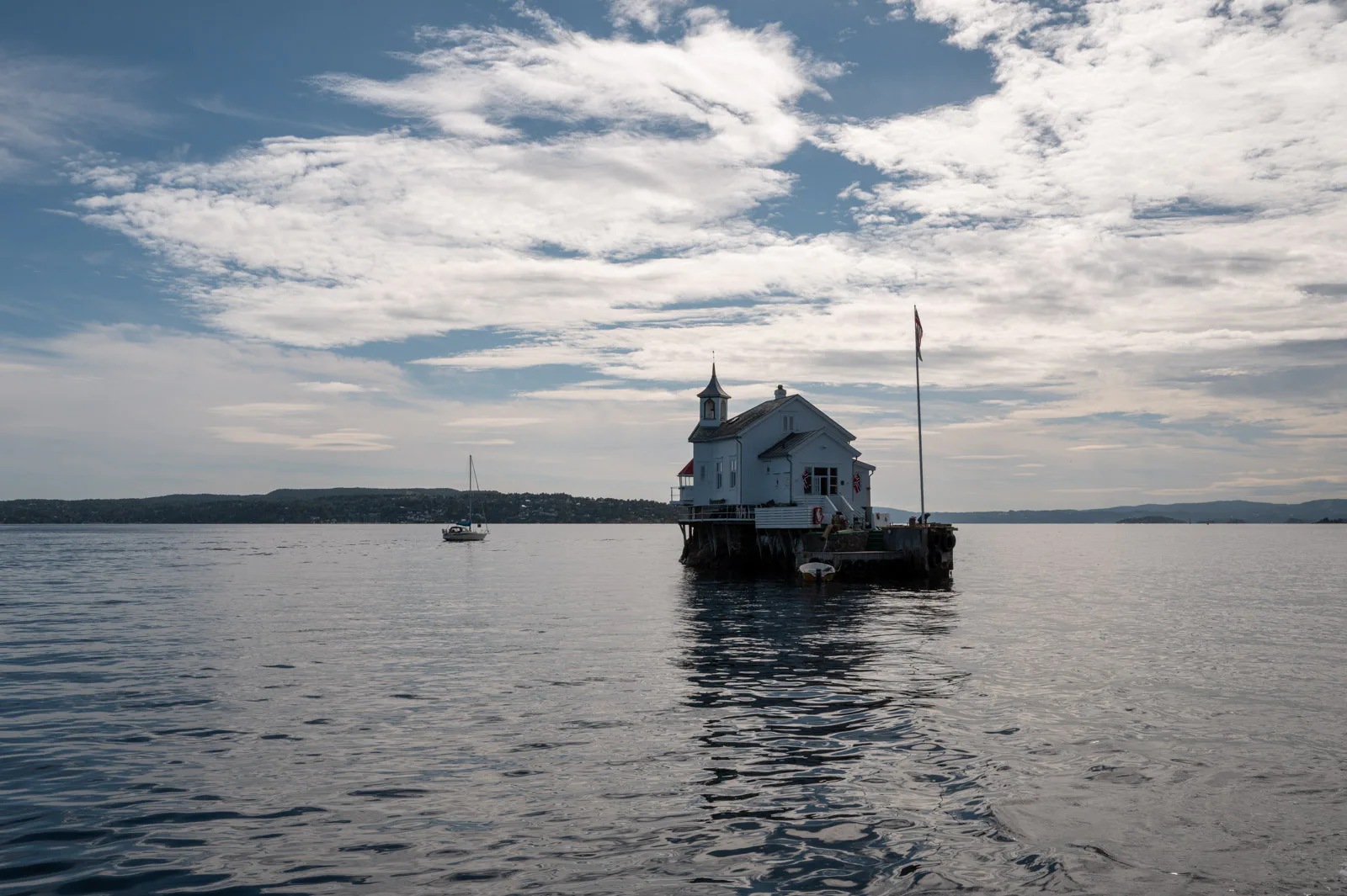 Le phare de Dyna seul sur l’eau, sous un ciel de nuages, Oslo