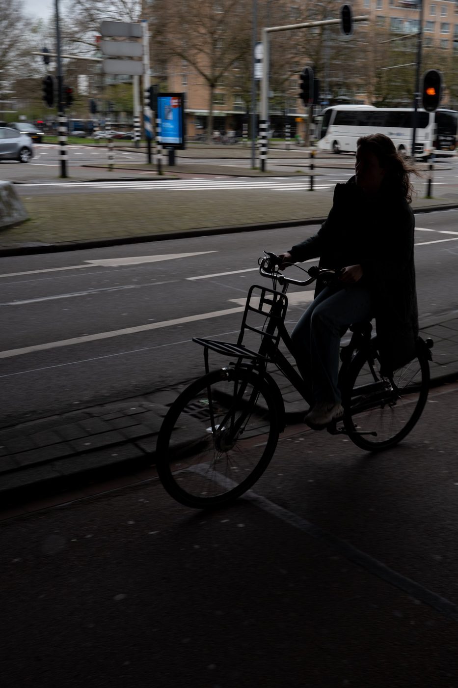 Backlit cyclist crossing an intersection at a red light, Rotterdam