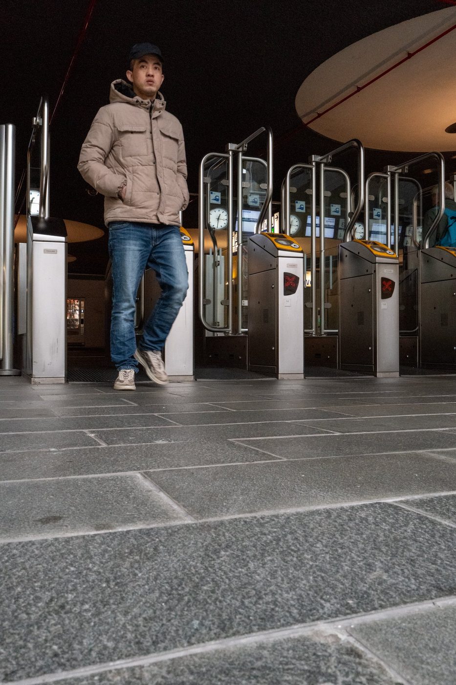 Traveler passing through the metro access gates at night, Rotterdam