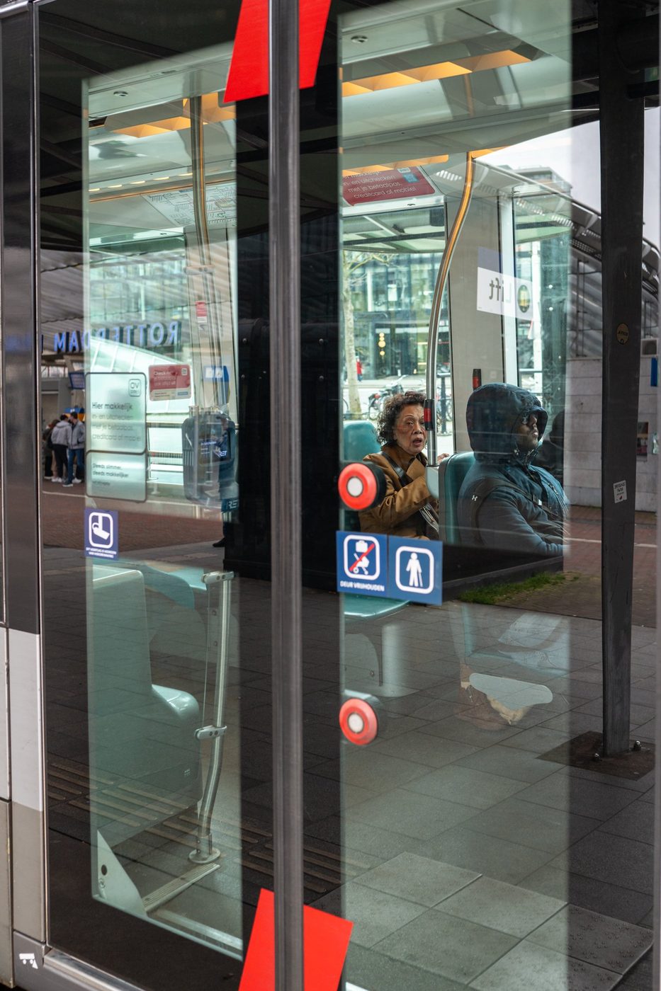 Passengers seated on a tram seen through the glass door, Rotterdam