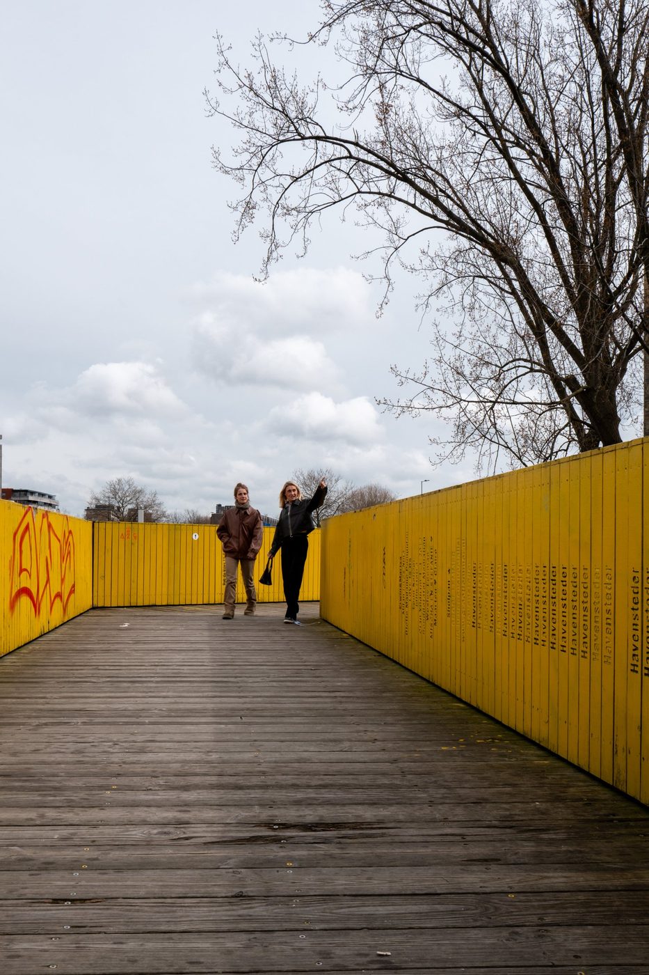 Two women walking on the named planks of the Luchtsingel, Rotterdam
