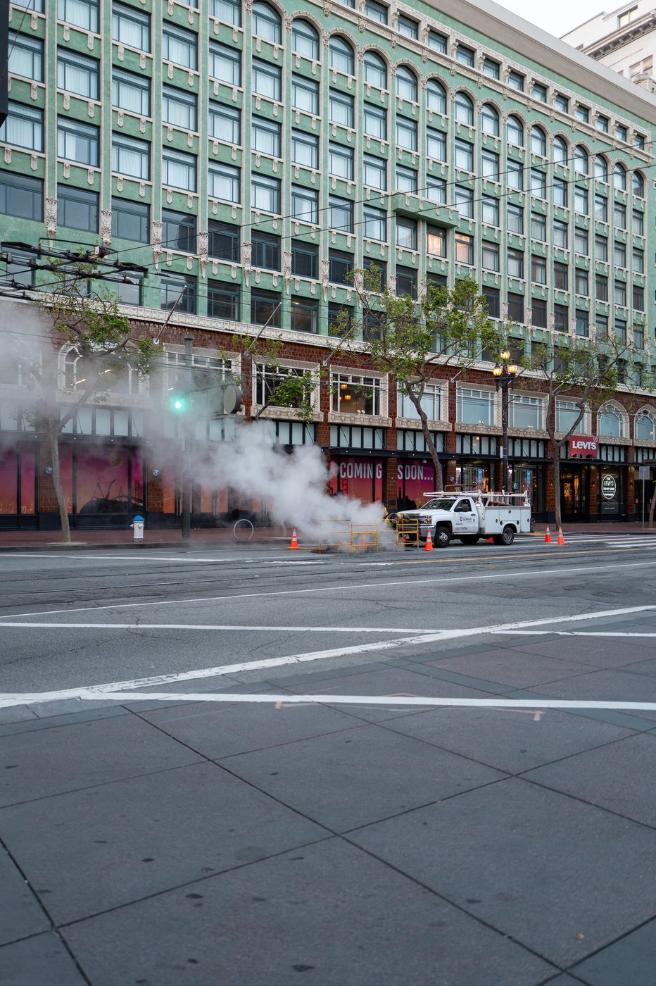 Green arcaded building with the Levi's sign, white steam rising from the street, San Francisco