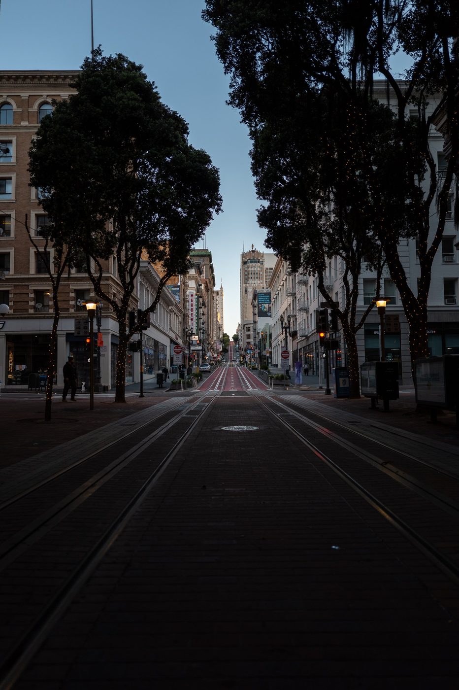 Streetcar rails sinking into a sloping street at nightfall, San Francisco