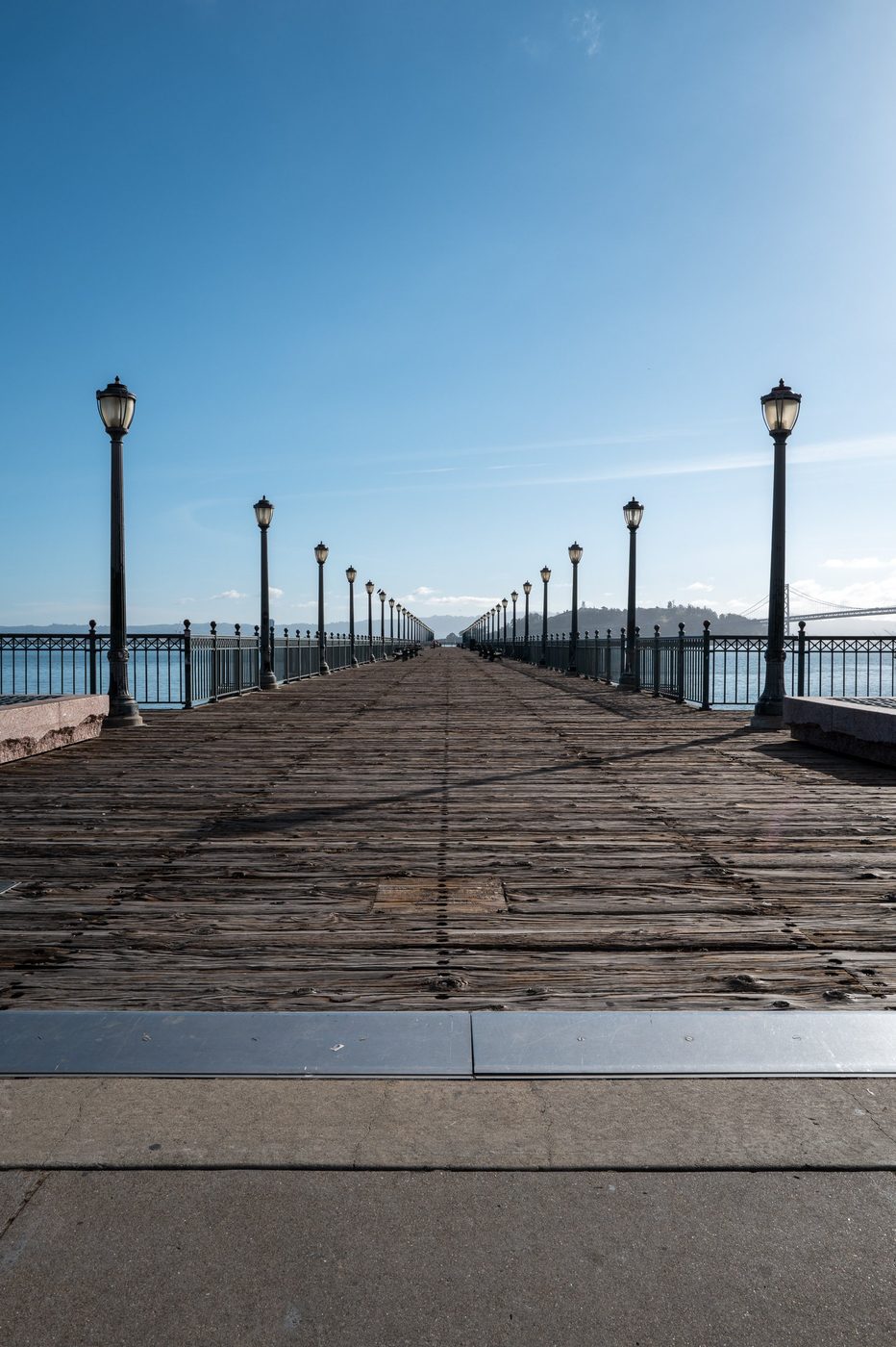 Long wooden pier lined with lampposts stretching toward the horizon, San Francisco