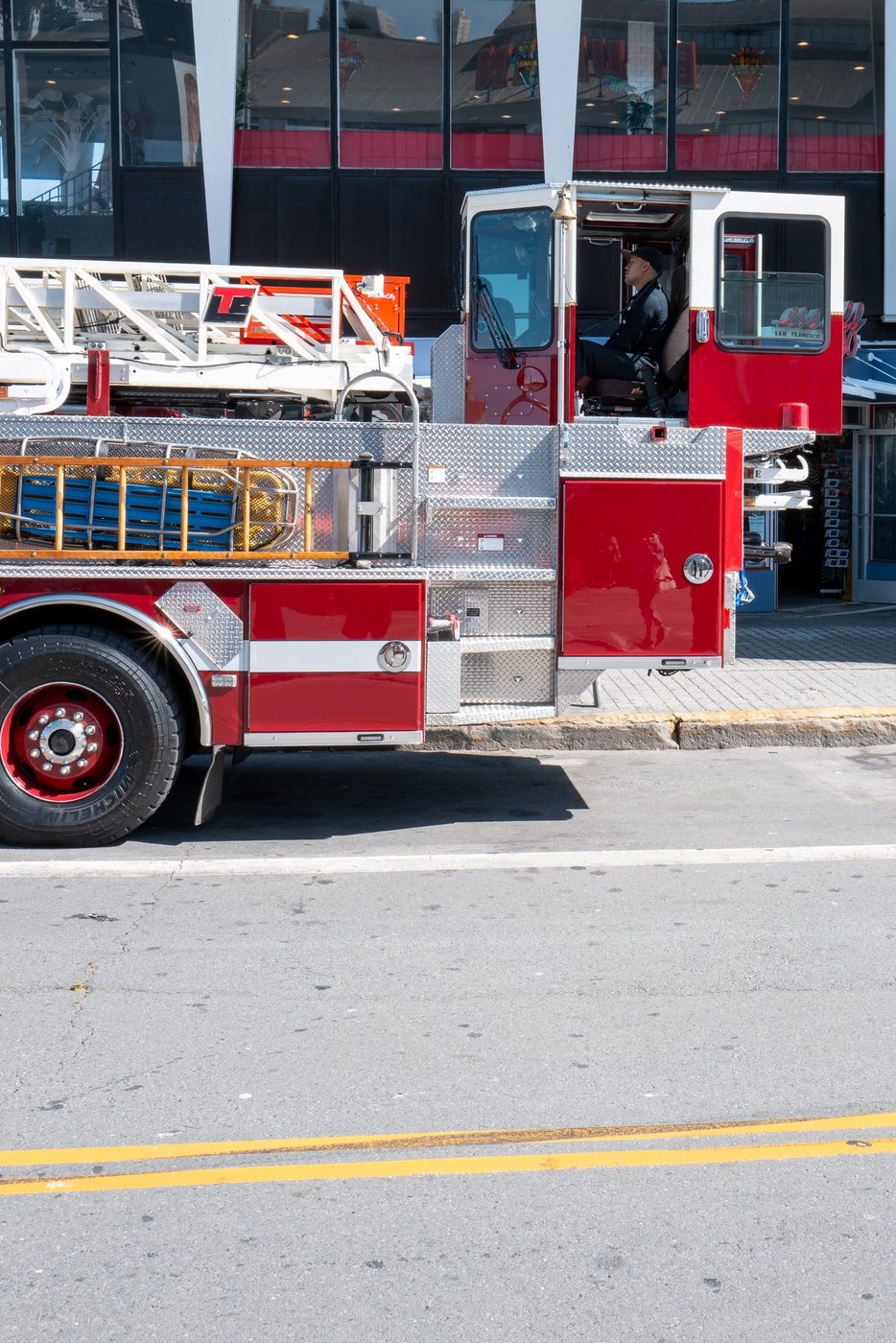 Fire truck with ladder seen from the side, firefighter at the wheel, San Francisco