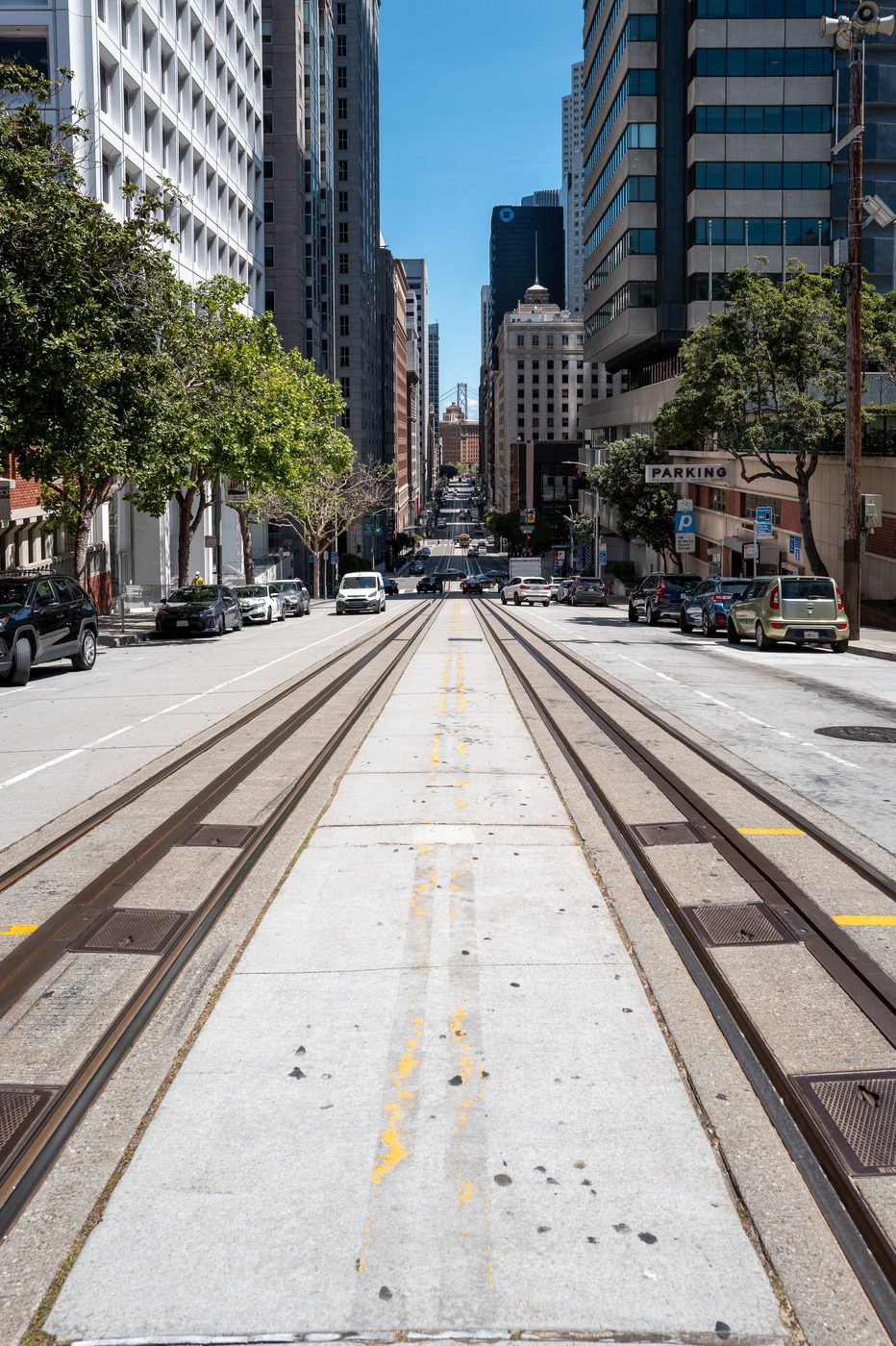 Streetcar rails plunging into California Street between the downtown towers, San Francisco