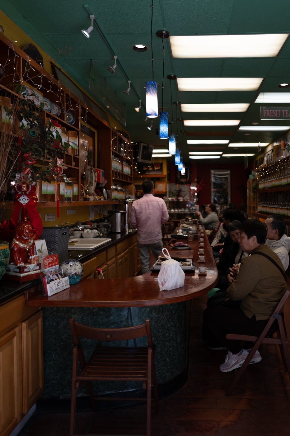 Curved counter of a Chinese tea house, customers seated in a row enjoying tea, San Francisco