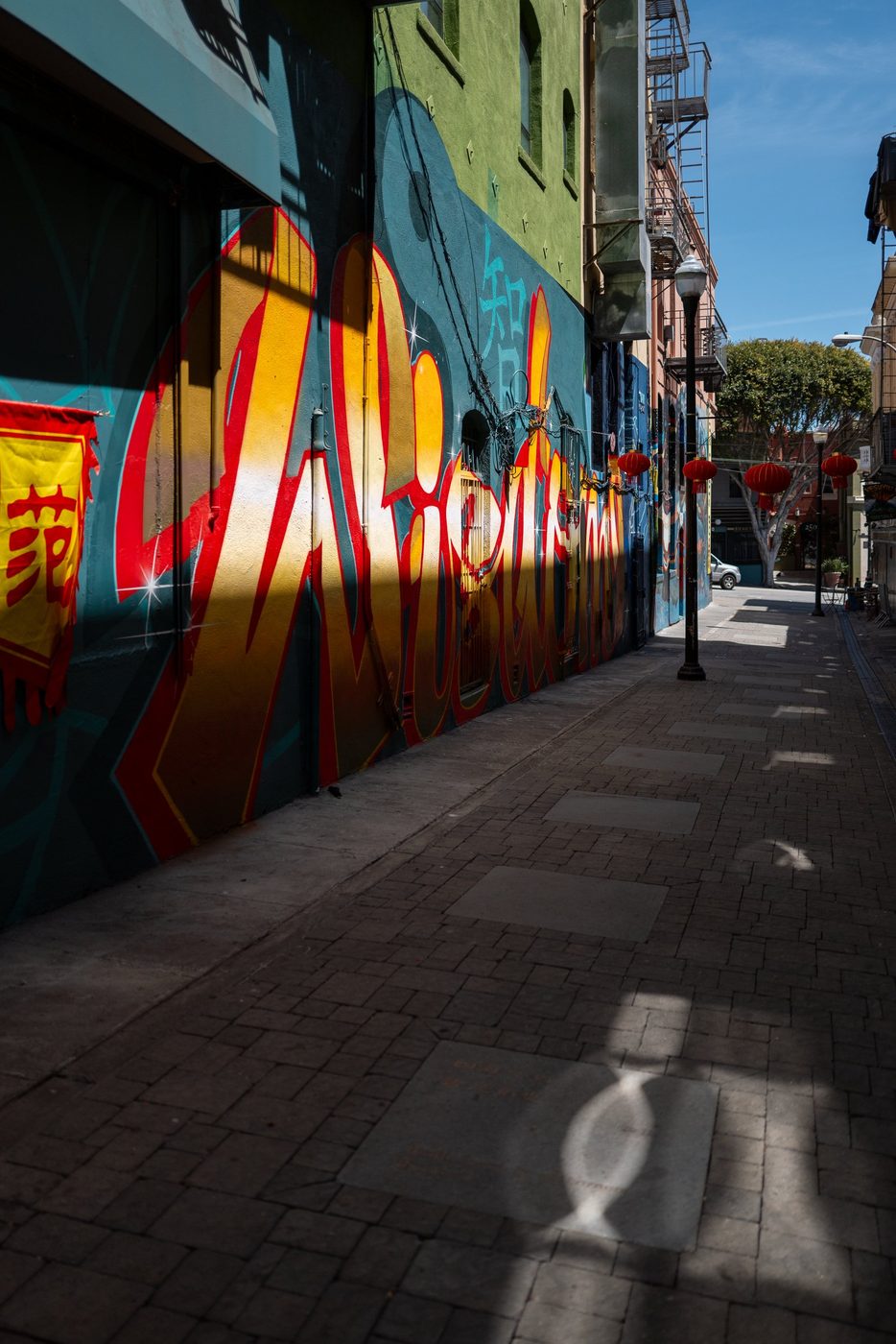 Chinatown alley with colorful graffiti and hanging red lanterns, San Francisco