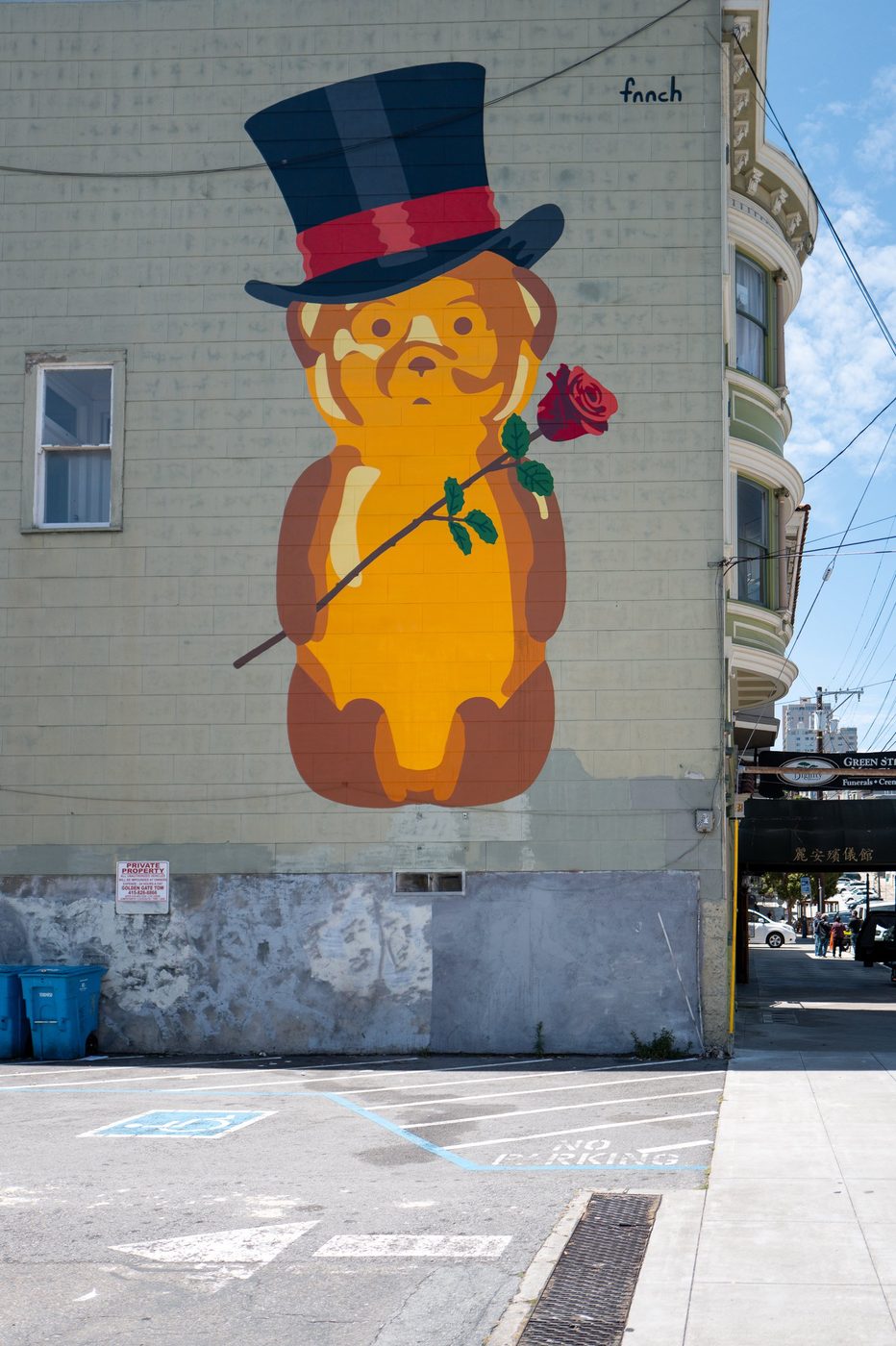 Mural of a bear in a top hat holding a rose, street art by fnnch, San Francisco