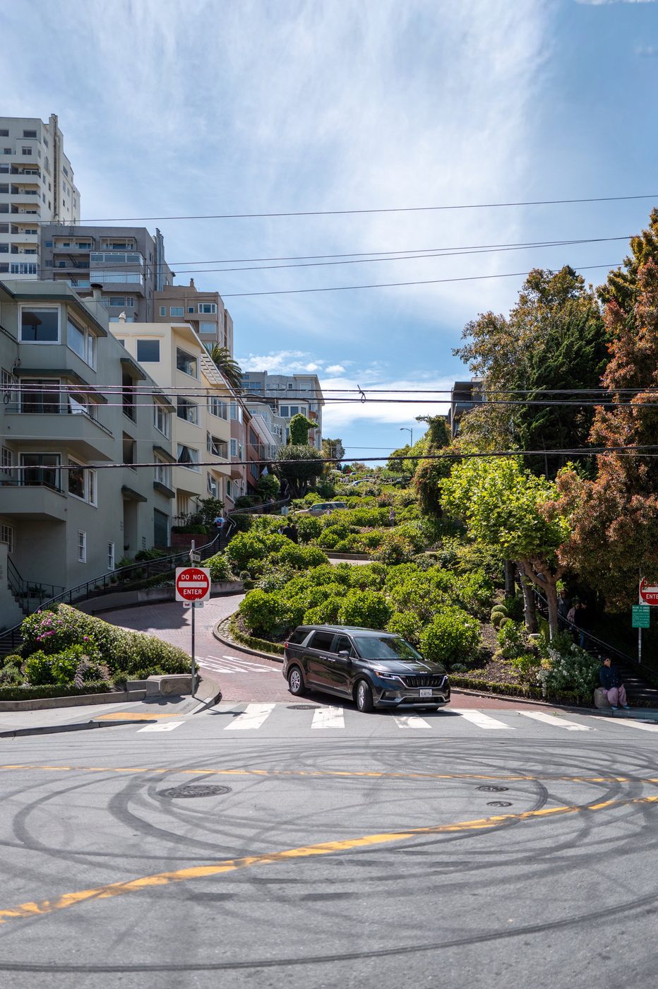 Hairpin bend of Lombard Street lined with flower beds, car at the crosswalk, San Francisco
