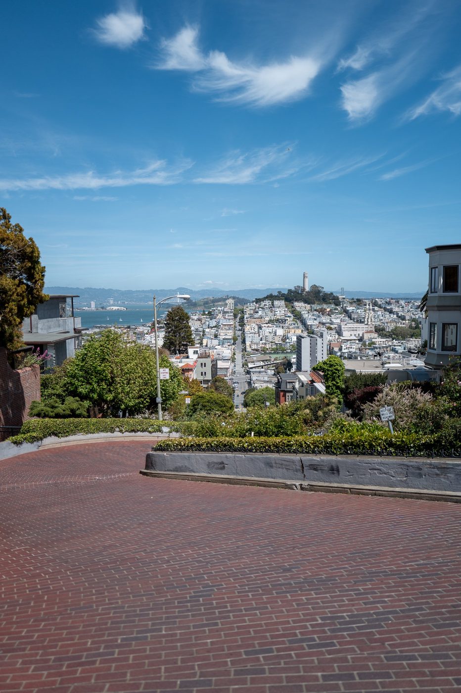 Overhead view of winding Lombard Street down to the bay, Coit Tower in the distance, San Francisco