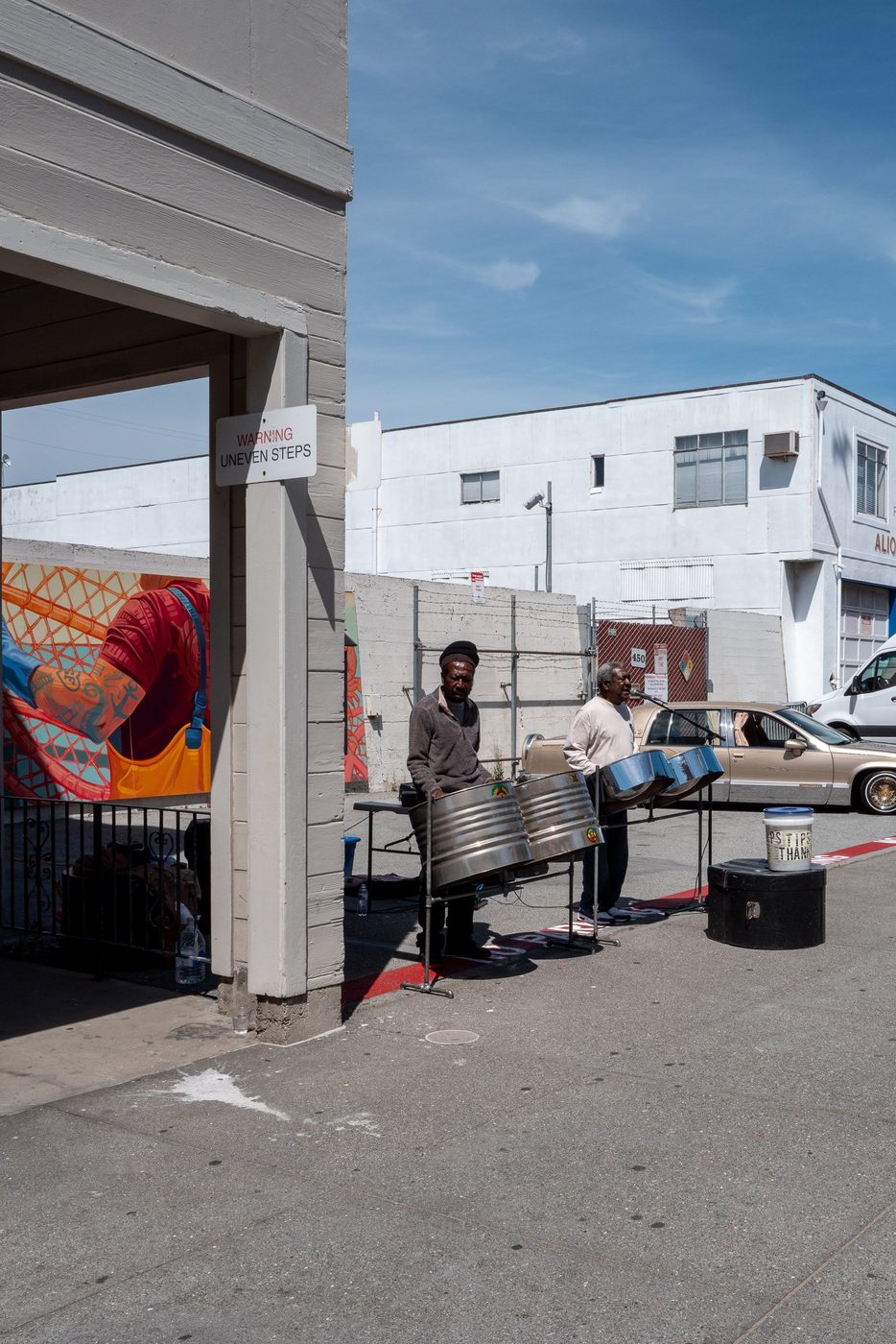 Street musicians playing steel drums in front of a colorful mural, San Francisco