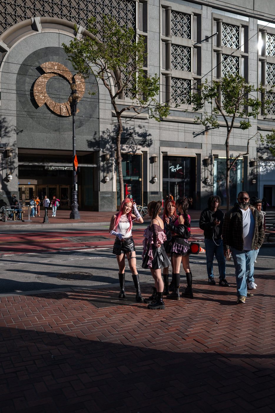 Group of young women with colorful hair gathered on a paved square, San Francisco