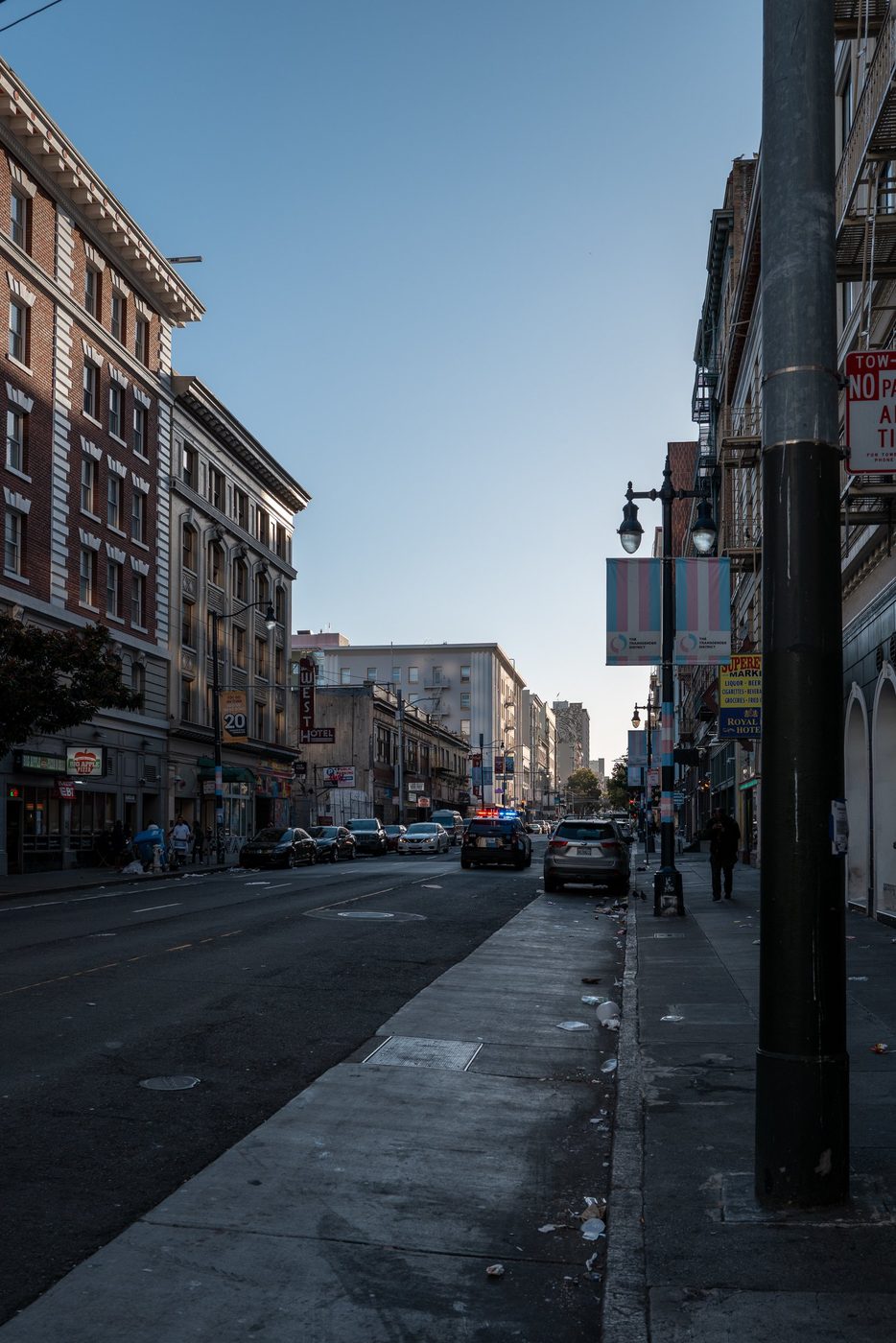 Tenderloin street in the early morning, police lights and the transgender district banner, San Francisco