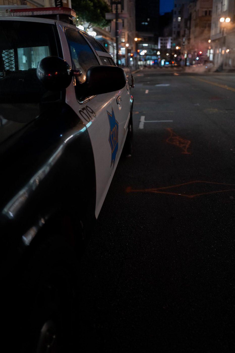 Door of an SFPD police car, night close-up on the badge, San Francisco