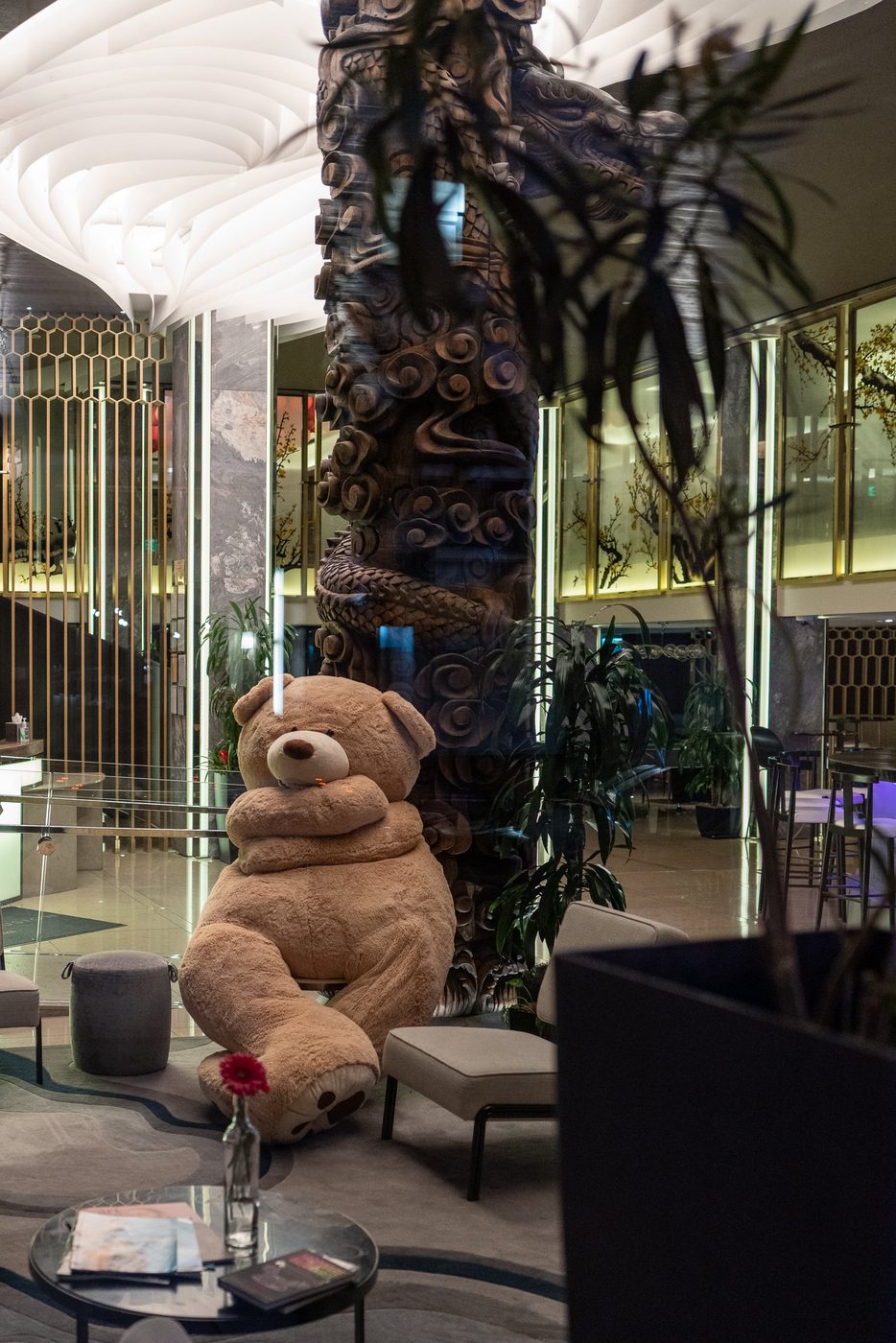Giant teddy bear sitting near a carved column in a hotel lobby, San Francisco