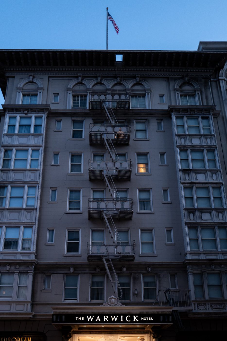 Zigzag fire escape on the façade of the Warwick Hotel, flag at the top, San Francisco