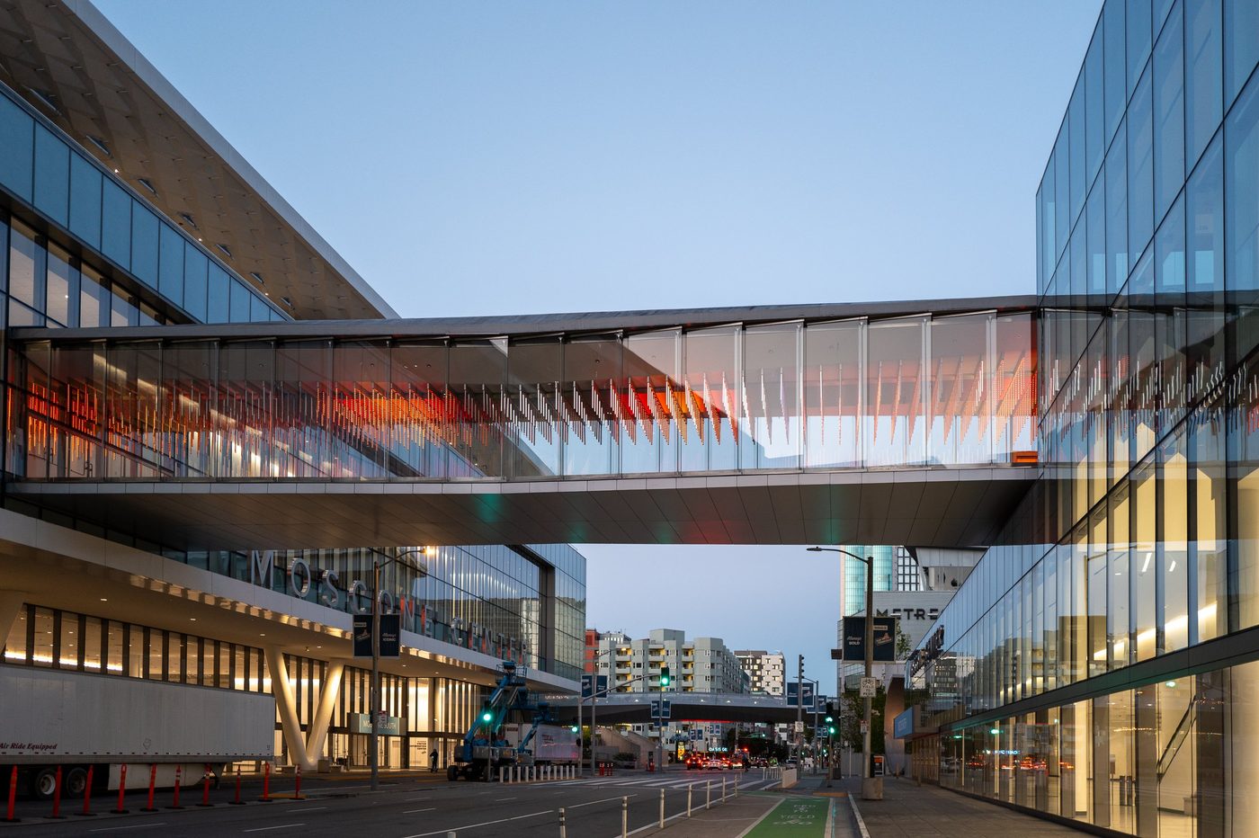 Glazed walkway connecting the Moscone Center buildings, orange lights at dusk, San Francisco