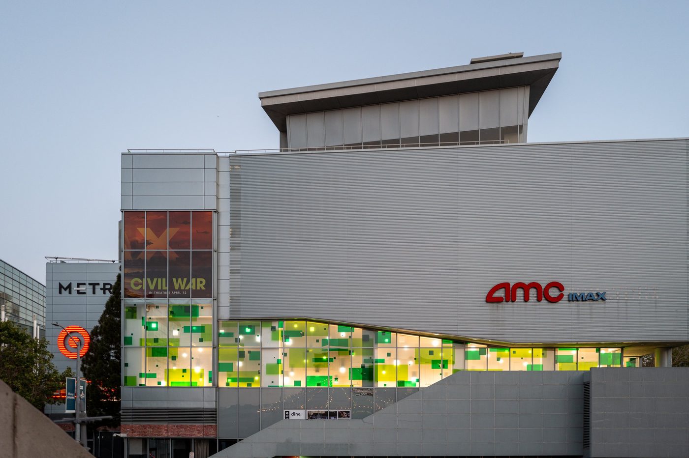 AMC IMAX cinema with a façade illuminated in green patterns, film poster at the entrance, San Francisco