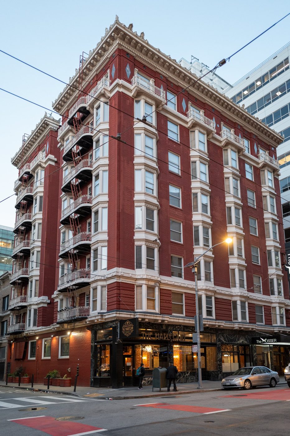 The Harlequin, a red-brick corner building, red crosswalk on the ground, San Francisco