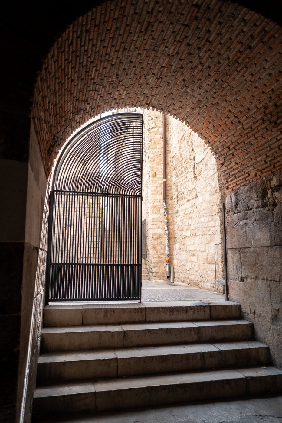 Arch-shaped iron gate at the top of a vaulted staircase, Split