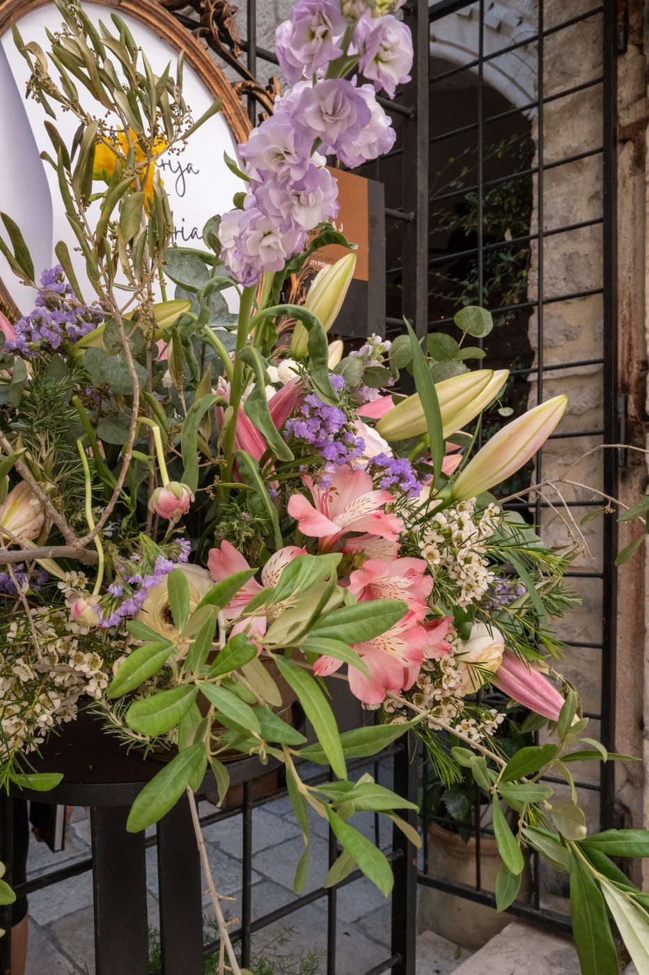 Bouquet of pink and purple flowers in front of an iron gate, Split