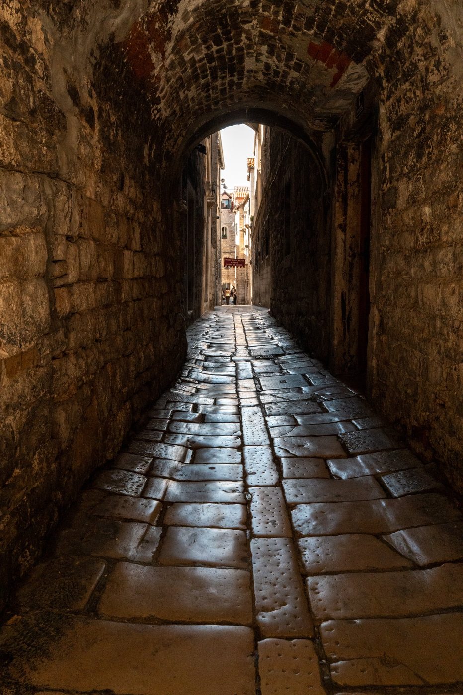 Vaulted tunnel with polished stones reflecting daylight, Split