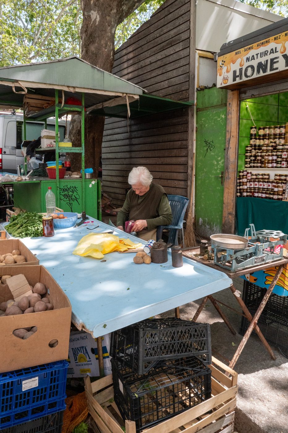 Vegetable vendor peeling potatoes at the market, Split