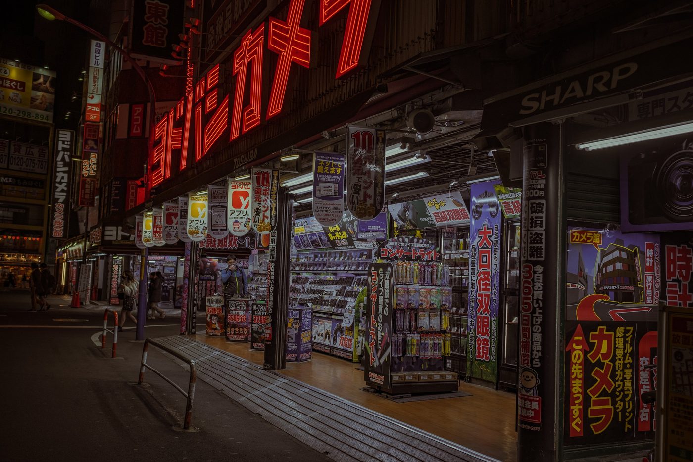 Red neon lights of a photo shop illuminating a deserted night street, Tokyo