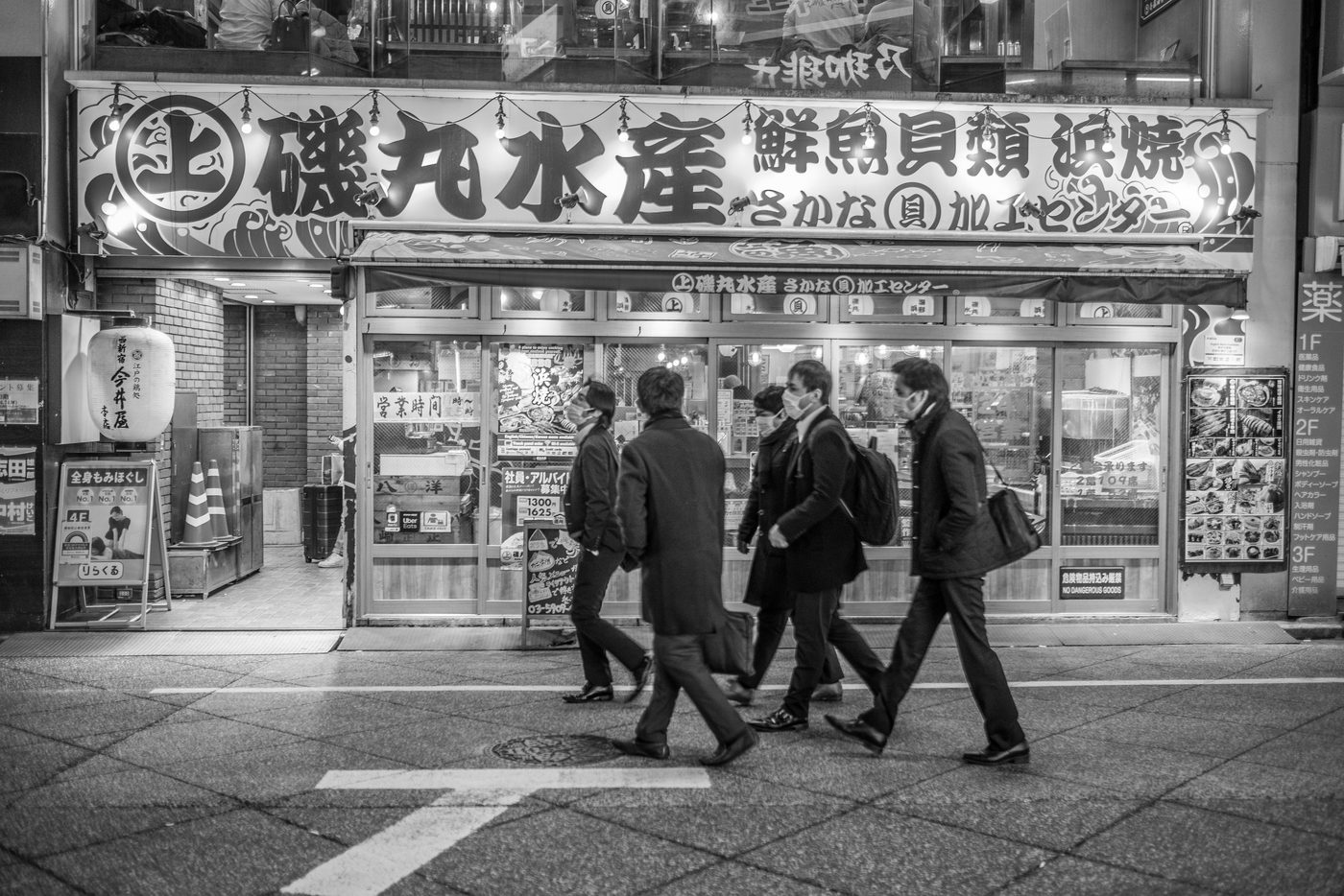 Arched entrance beneath a neon dragon sign, silhouettes gathered at the Yokocho, Tokyo
