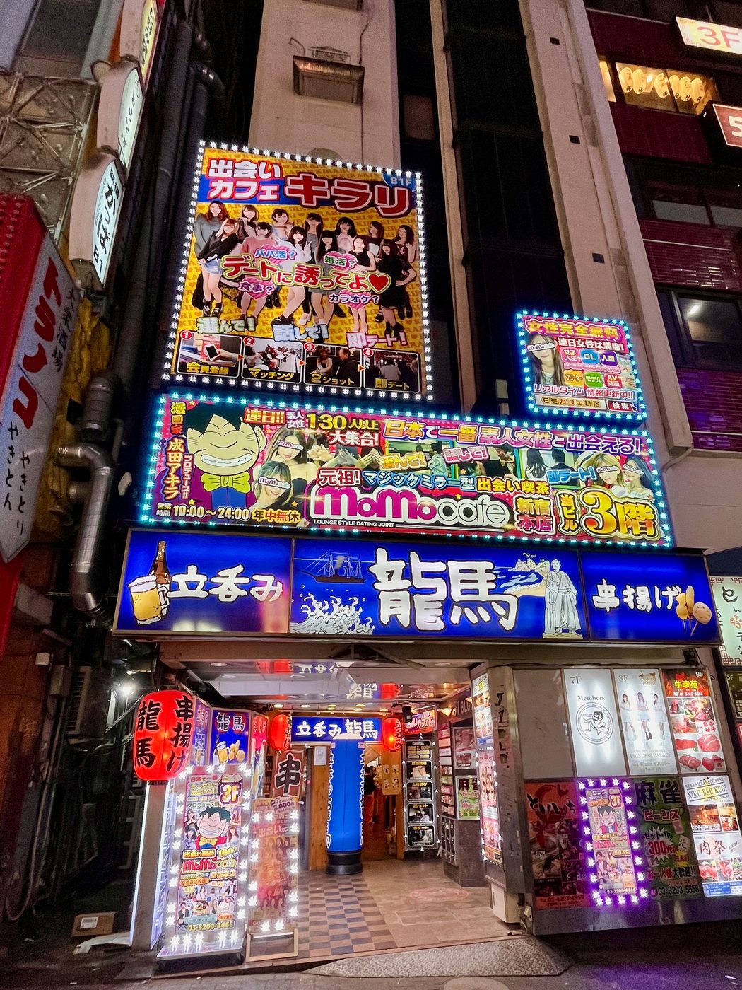 Vertical façade saturated with colorful signs for bars and dating cafés, Tokyo