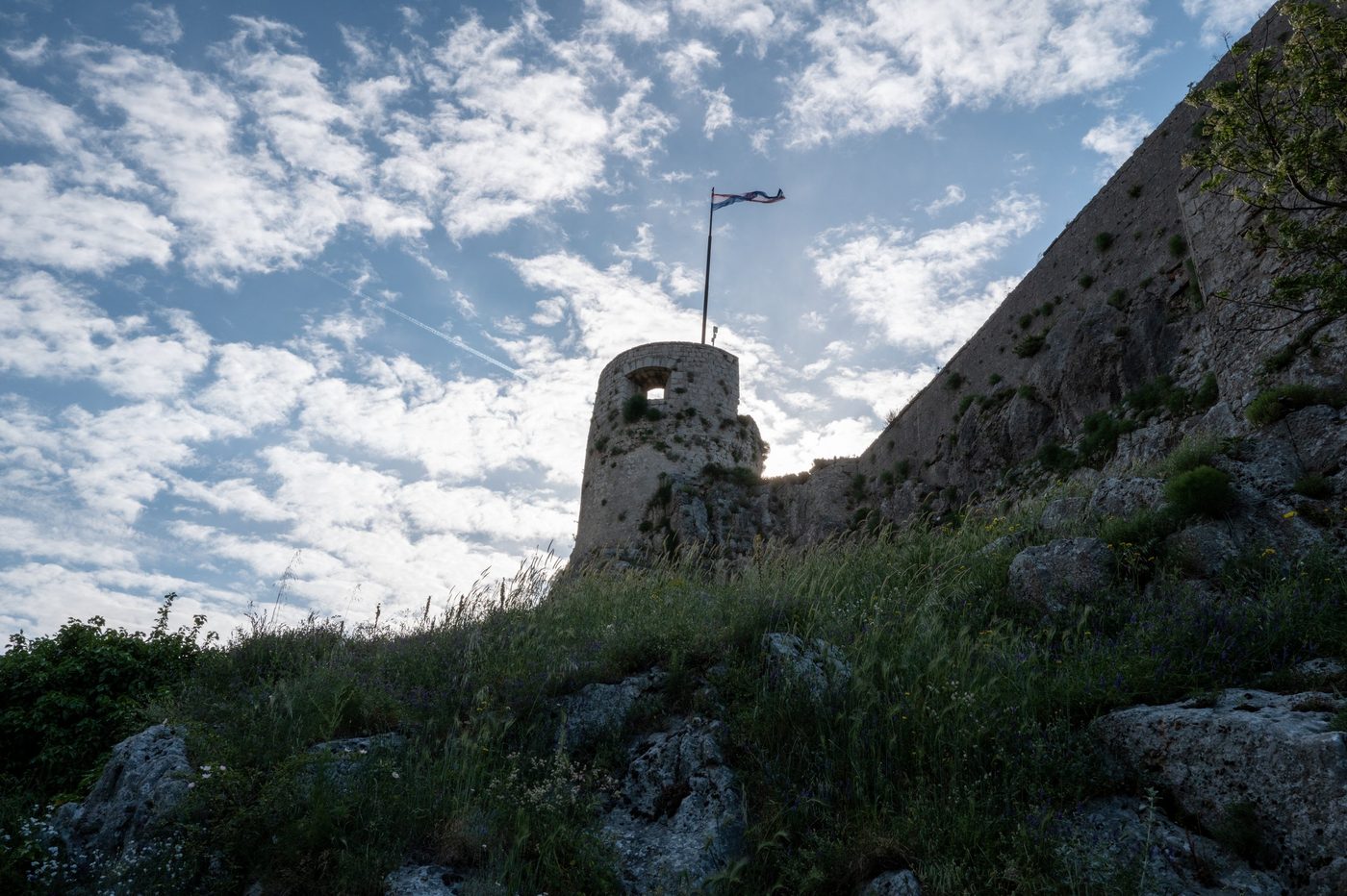 Fortress tower backlit under a cloudy sky, Trogir