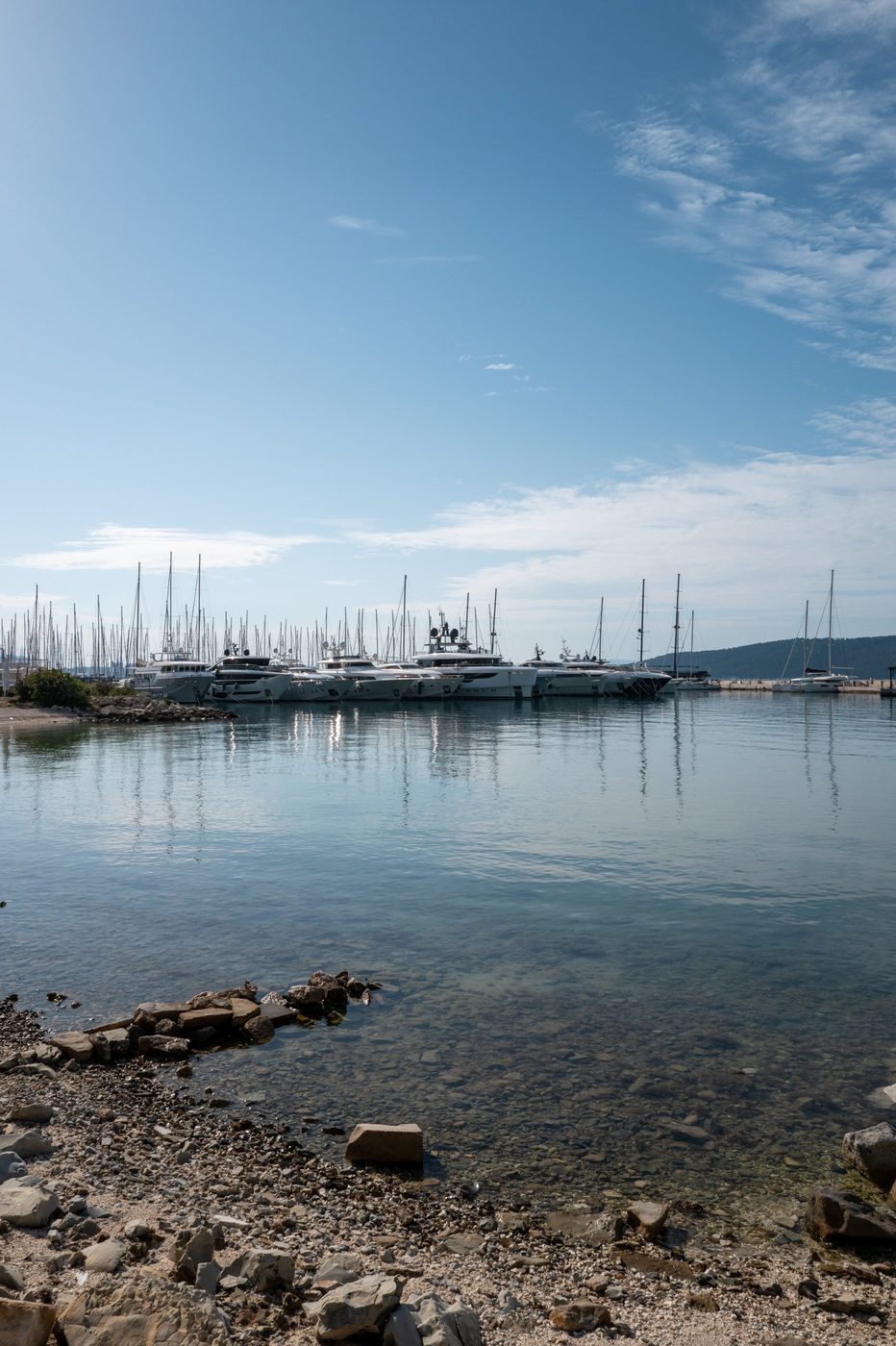 Row of yachts moored in the harbor, reflections on the calm water, Trogir