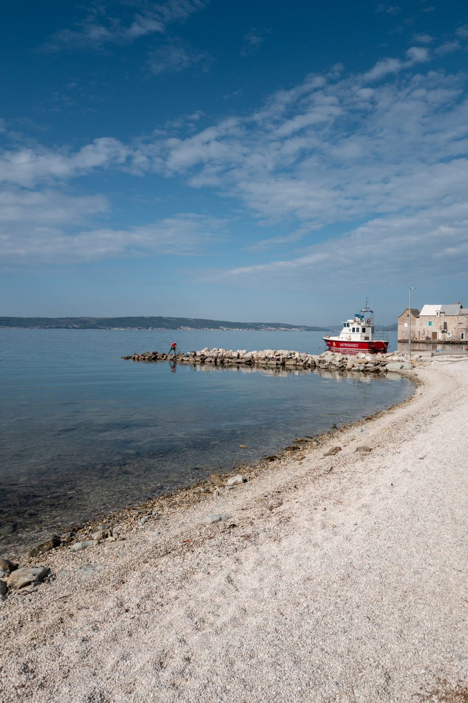 Fire boat moored at the end of a white pebble jetty, Trogir