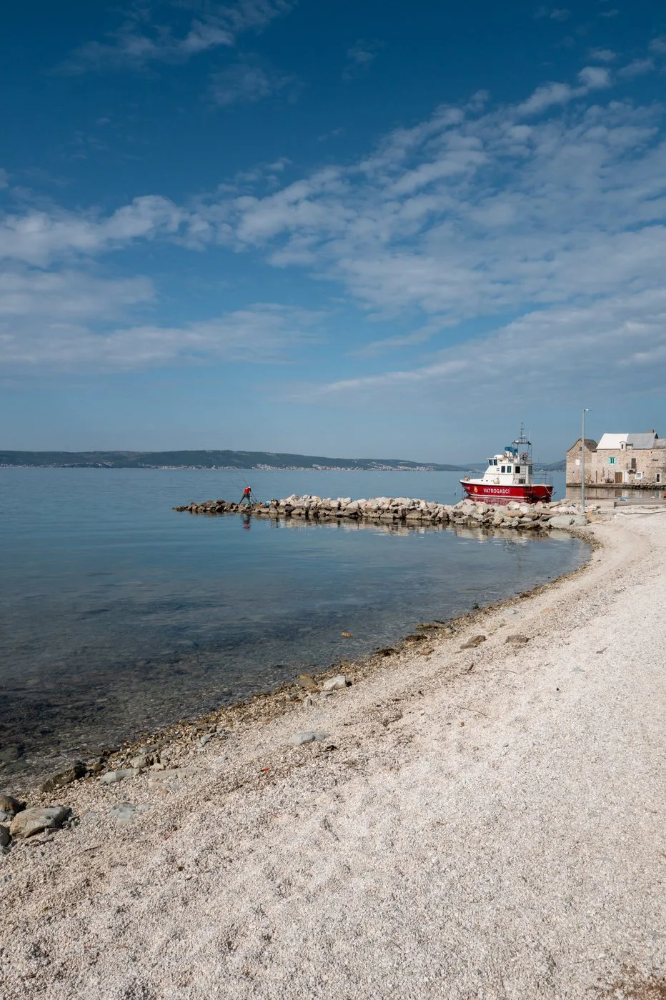 Bateau des pompiers amarré au bout d'une jetée de galets blancs, Trogir
