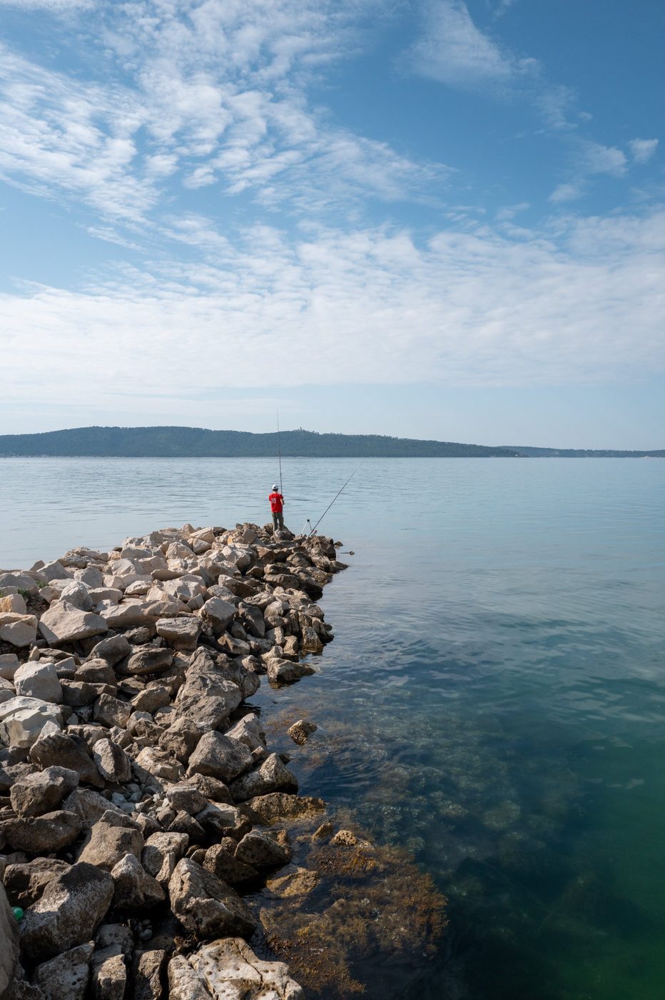 Fisherman casting his line from the jetty near the harbor, Trogir