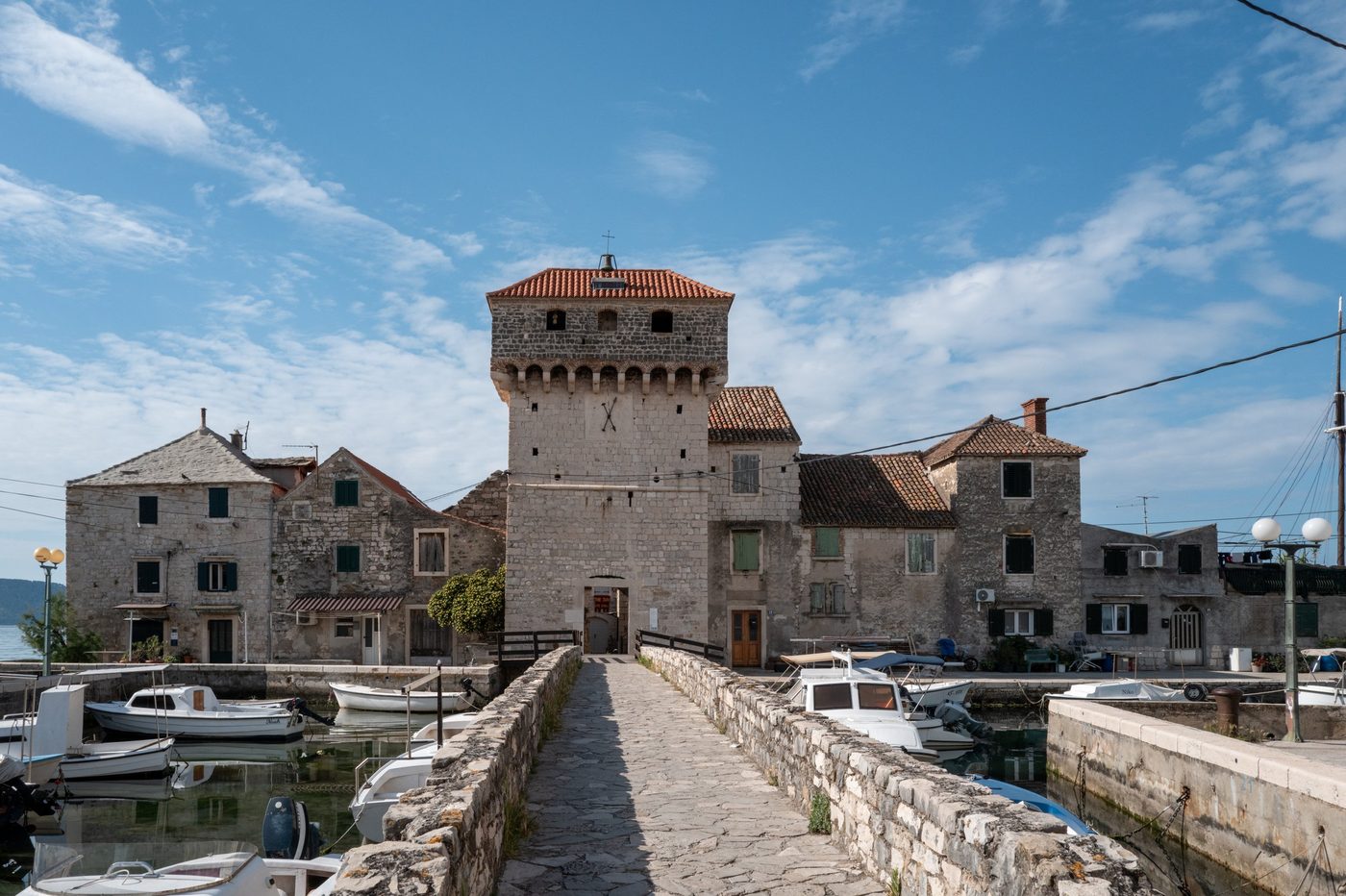 Medieval tower surrounded by stone houses and small boats, Trogir