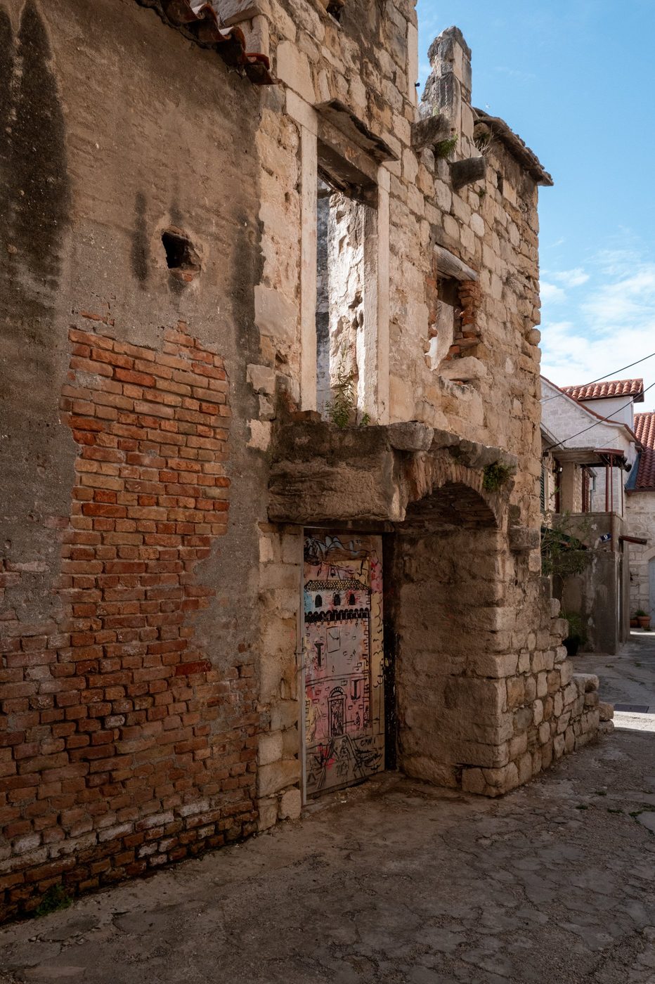 Door painted with a naive fresco on an old stone façade, Trogir