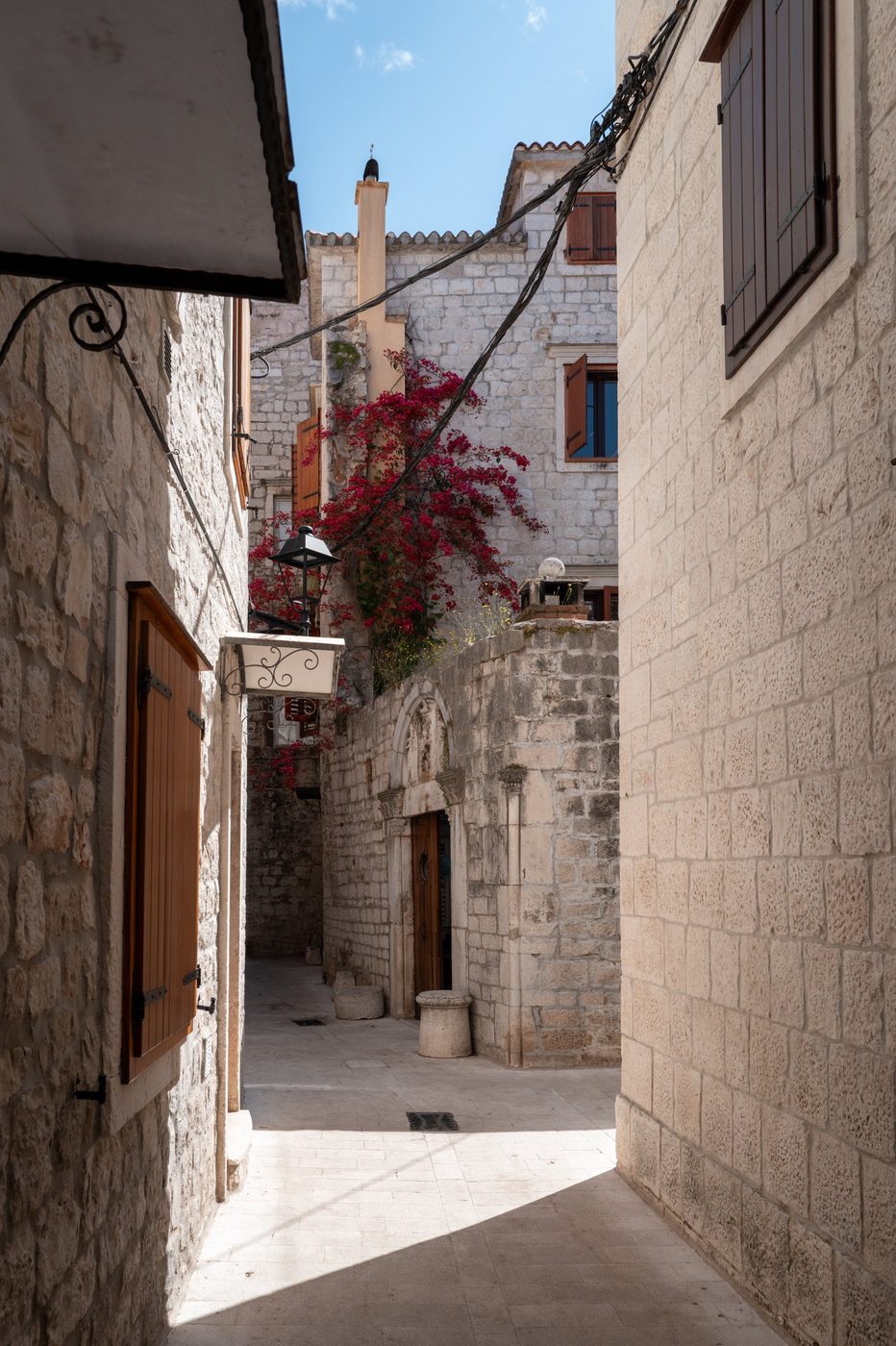 Fuchsia bougainvillea cascading over a stone façade, Trogir