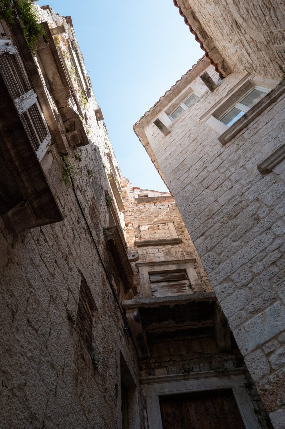 Narrow passage between two old façades seen from below, Trogir