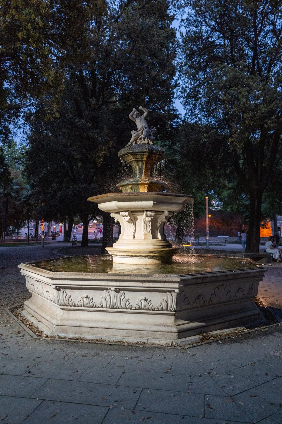 Tiered fountain lit at dusk in the public garden, Trogir