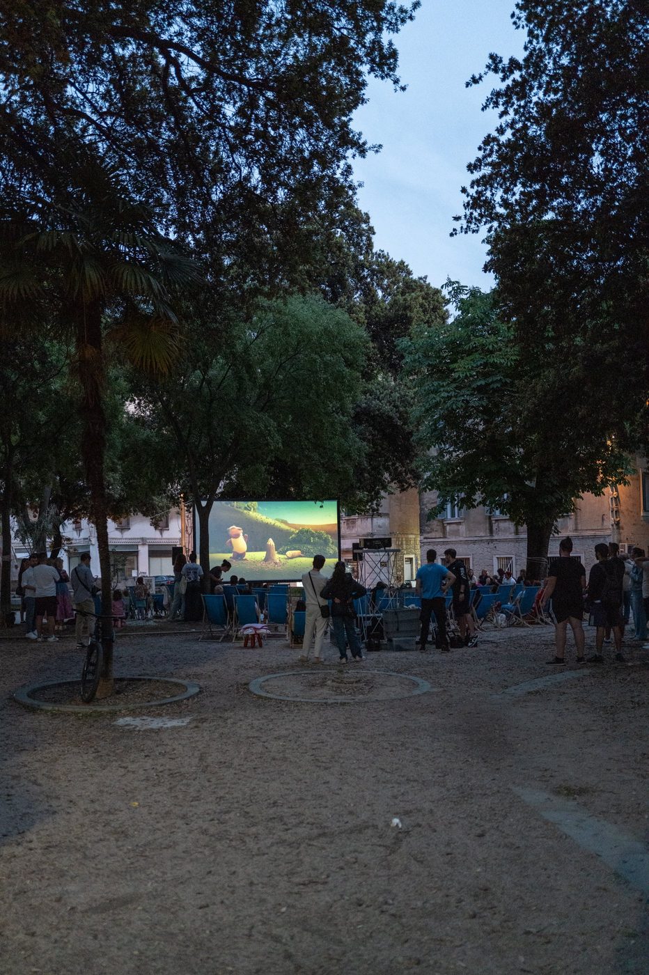 Outdoor film screening beneath the trees of the park, Trogir