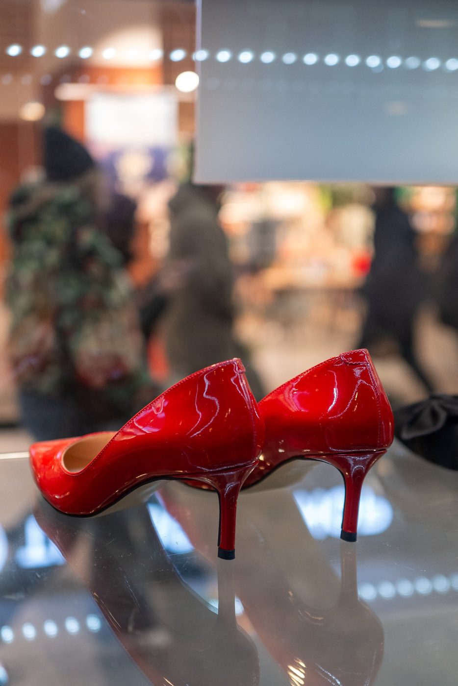 Red patent leather pumps displayed on a glass counter, Vienna