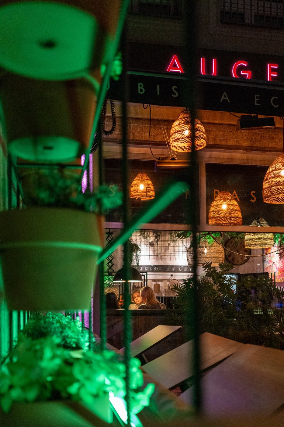 Wicker lanterns and red neon behind a curtain of plants, Vienna