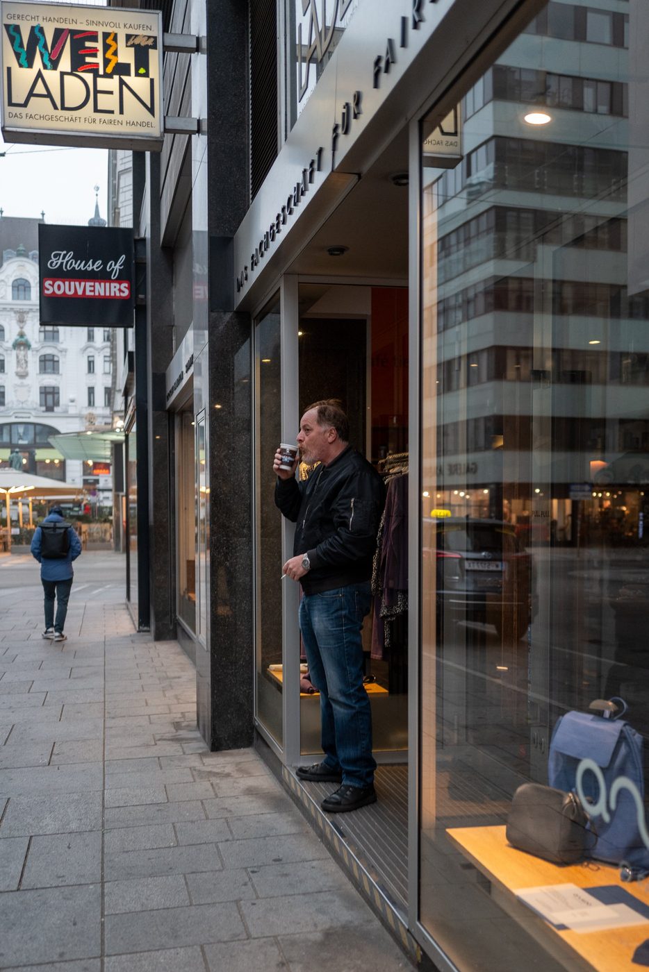 Man enjoying a coffee at the entrance of a fair-trade shop, Vienna